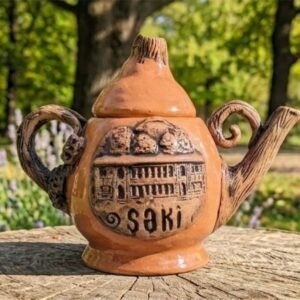 A high-definition handcrafted ceramic mug featuring a highly detailed, hand-sculpted 3D relief of the Sheki Khan’s Palace facade, with raw matte clay exterior and contrasting deep cobalt blue glaze on the handle, certified unique 1 of 1 by master Kamran Ibrahimkhalilov.